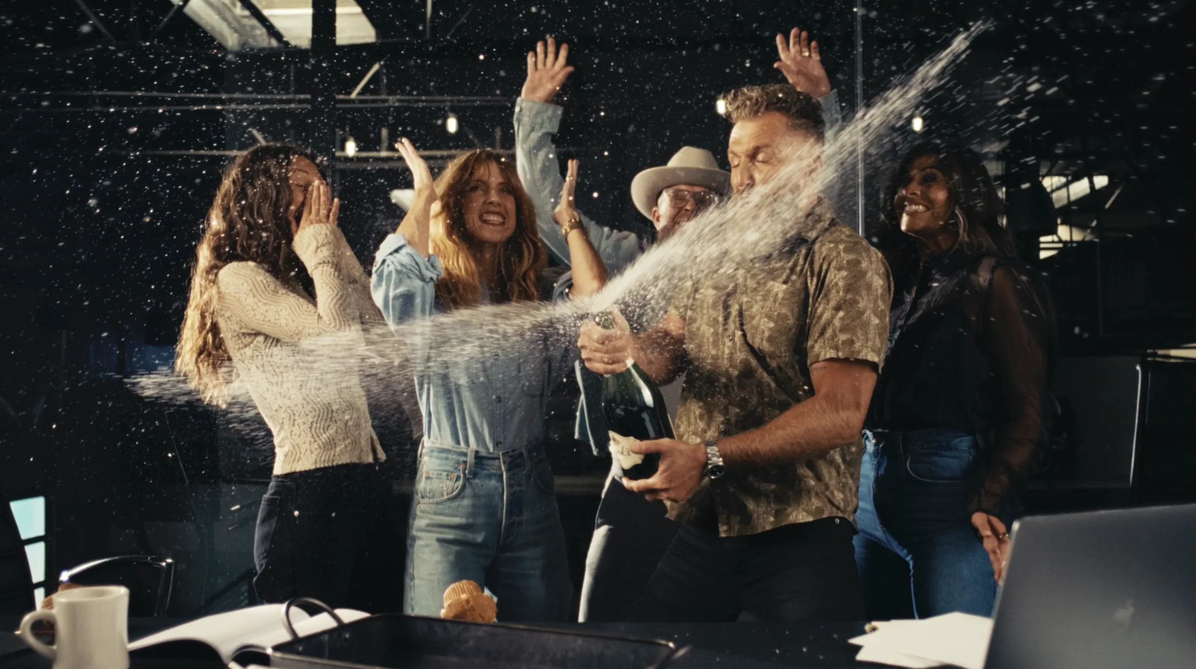 Creative team celebrating with champagne in a studio