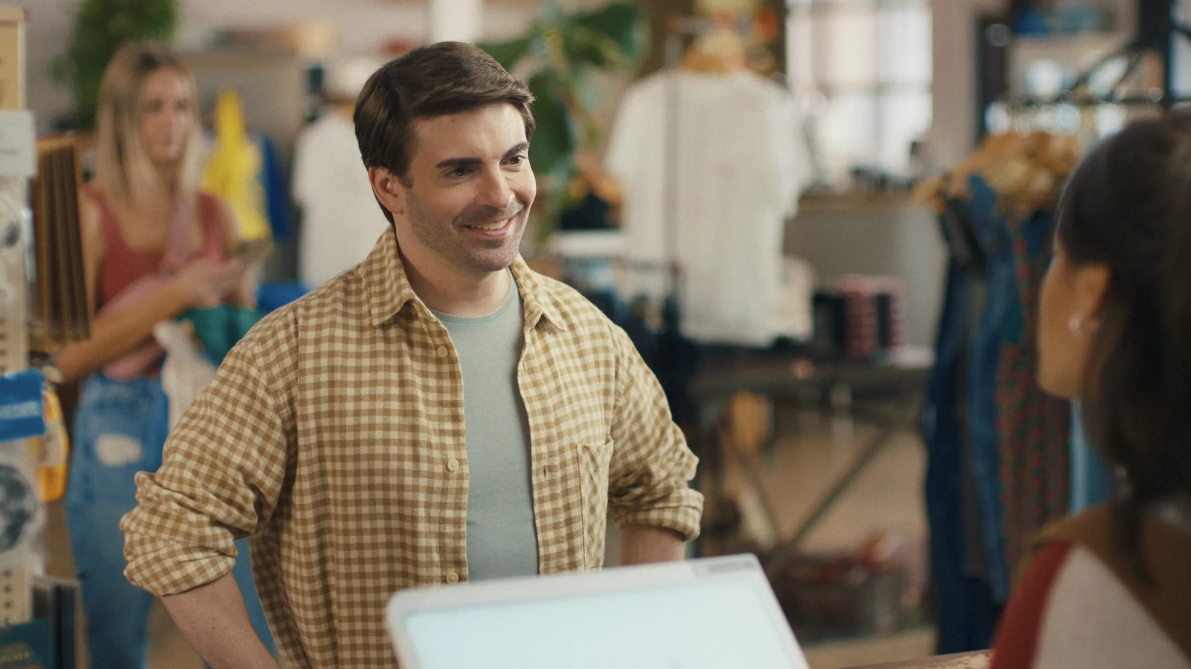 Customer in a gingham shirt at a shop counter