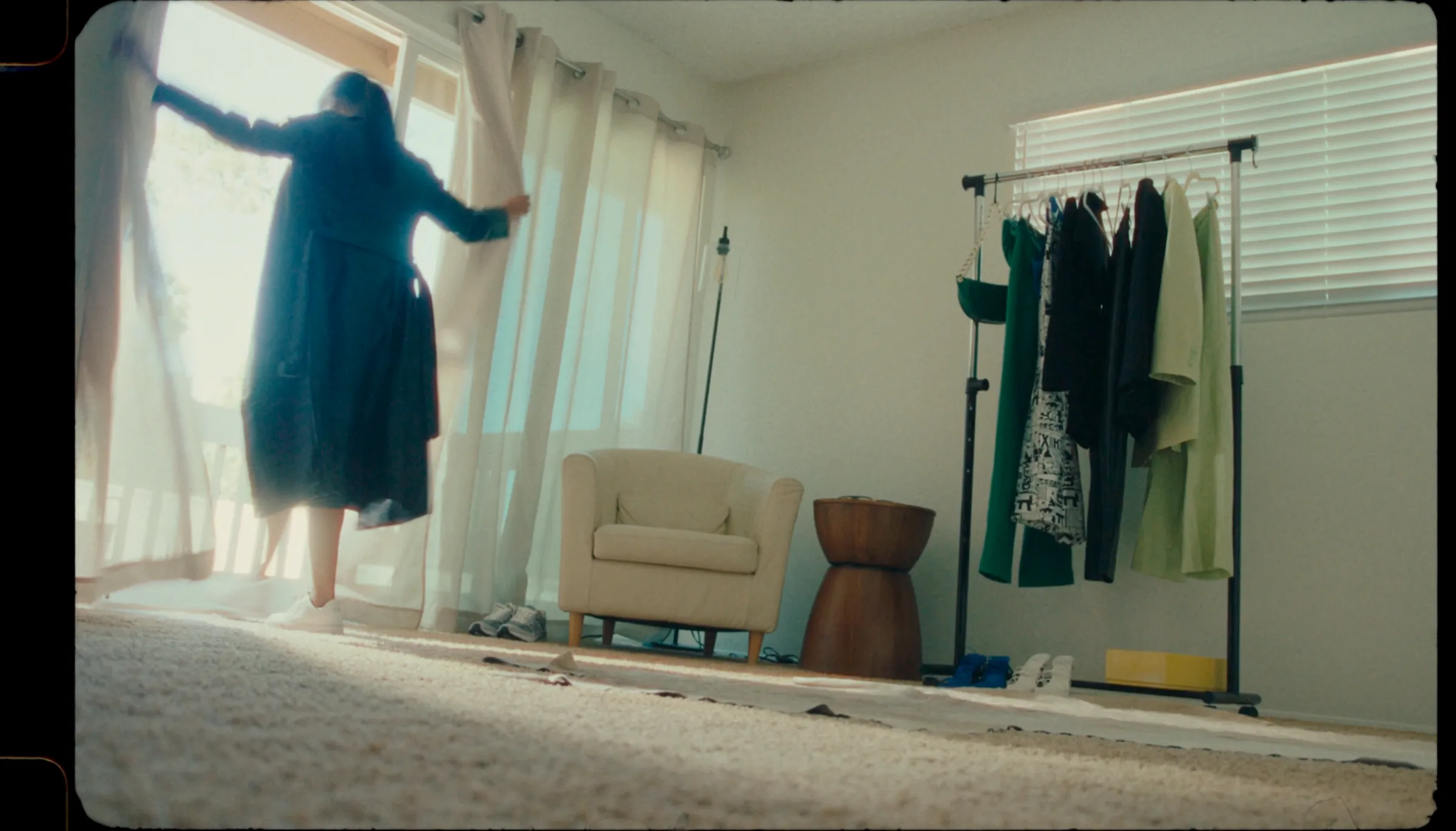Model beside a wardrobe rack in a bright interior