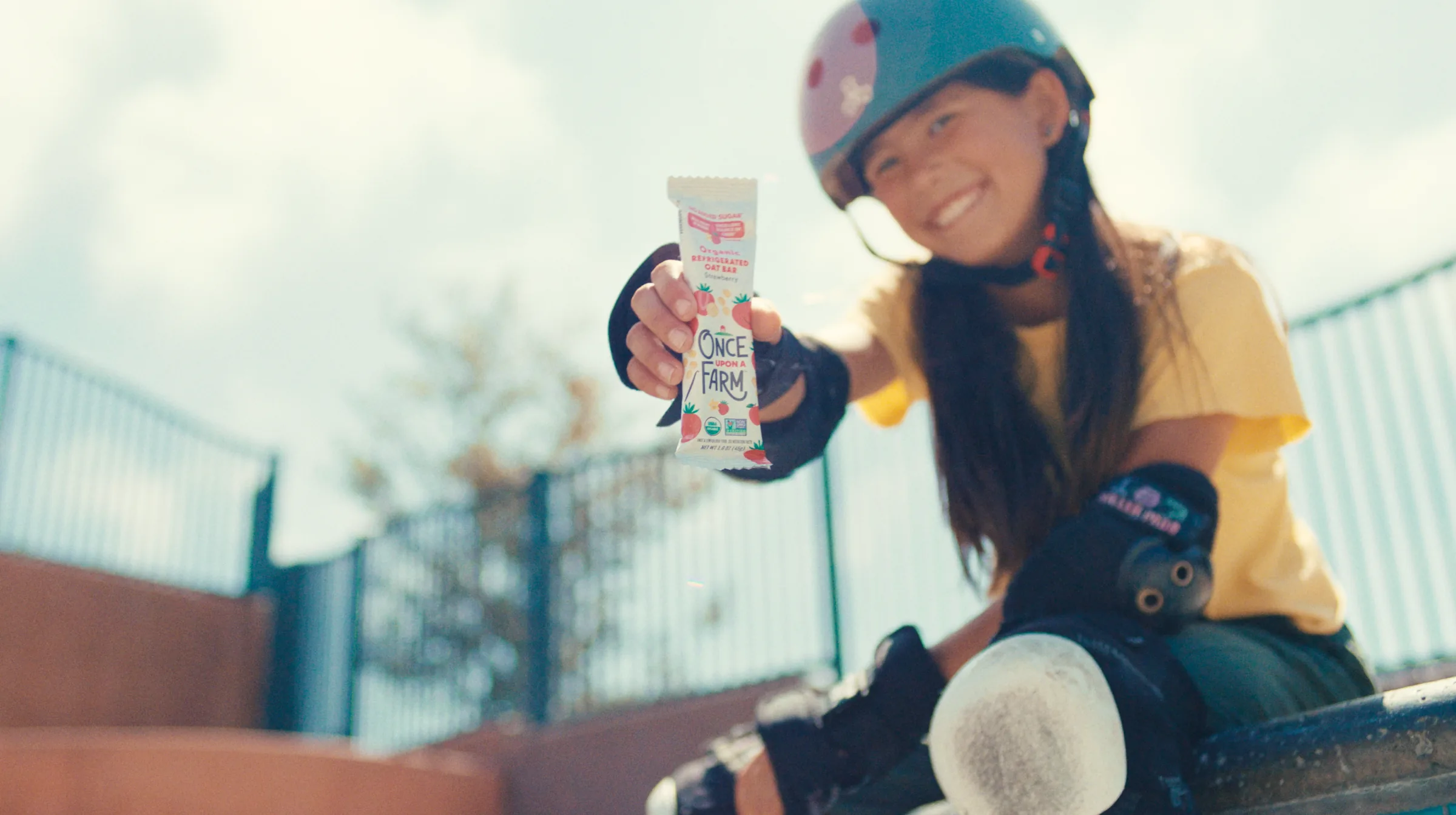 Skater holding a Once Upon a Farm oat bar