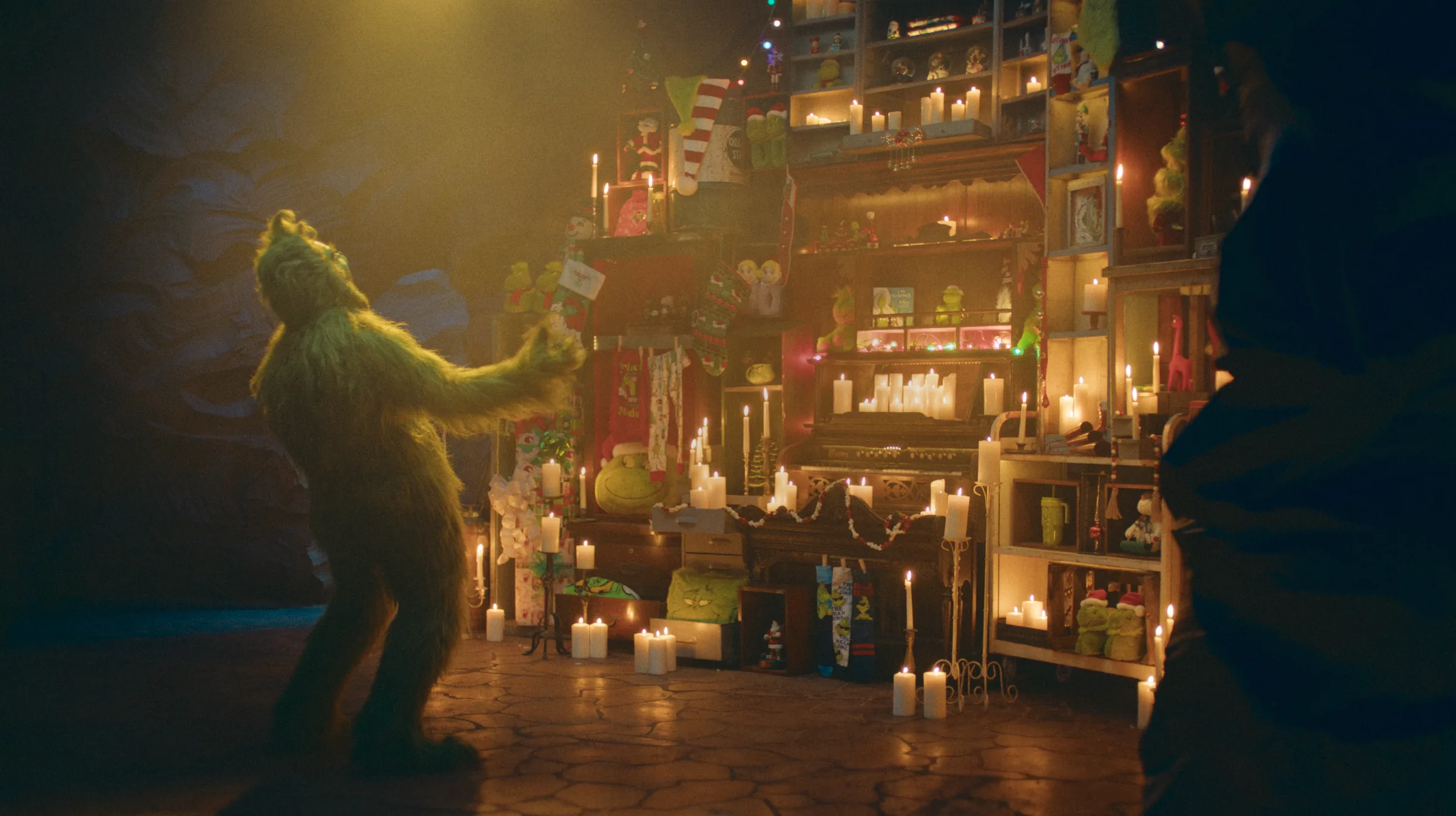 The Grinch performing in a candlelit holiday set