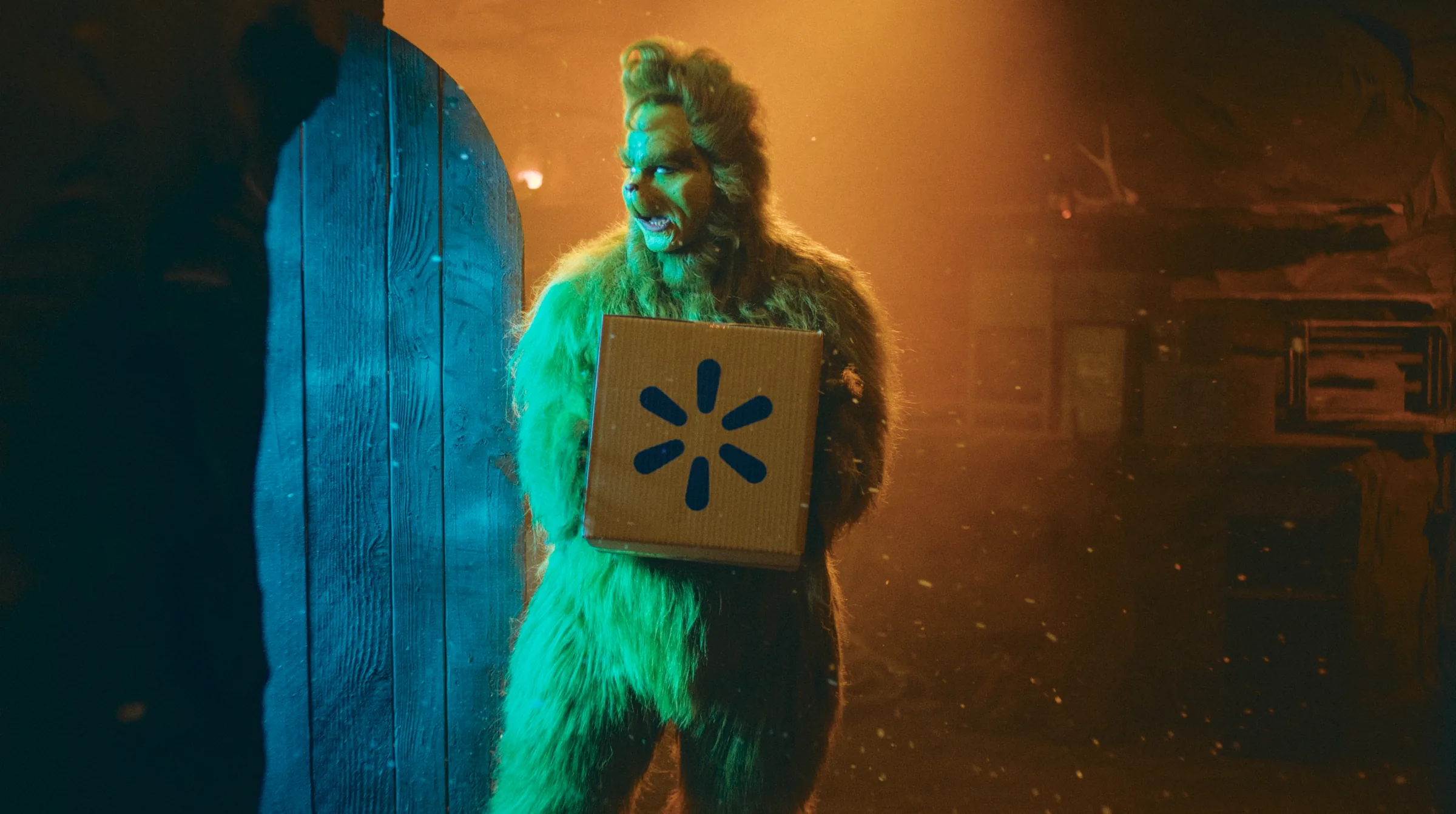 The Grinch holding a branded delivery box