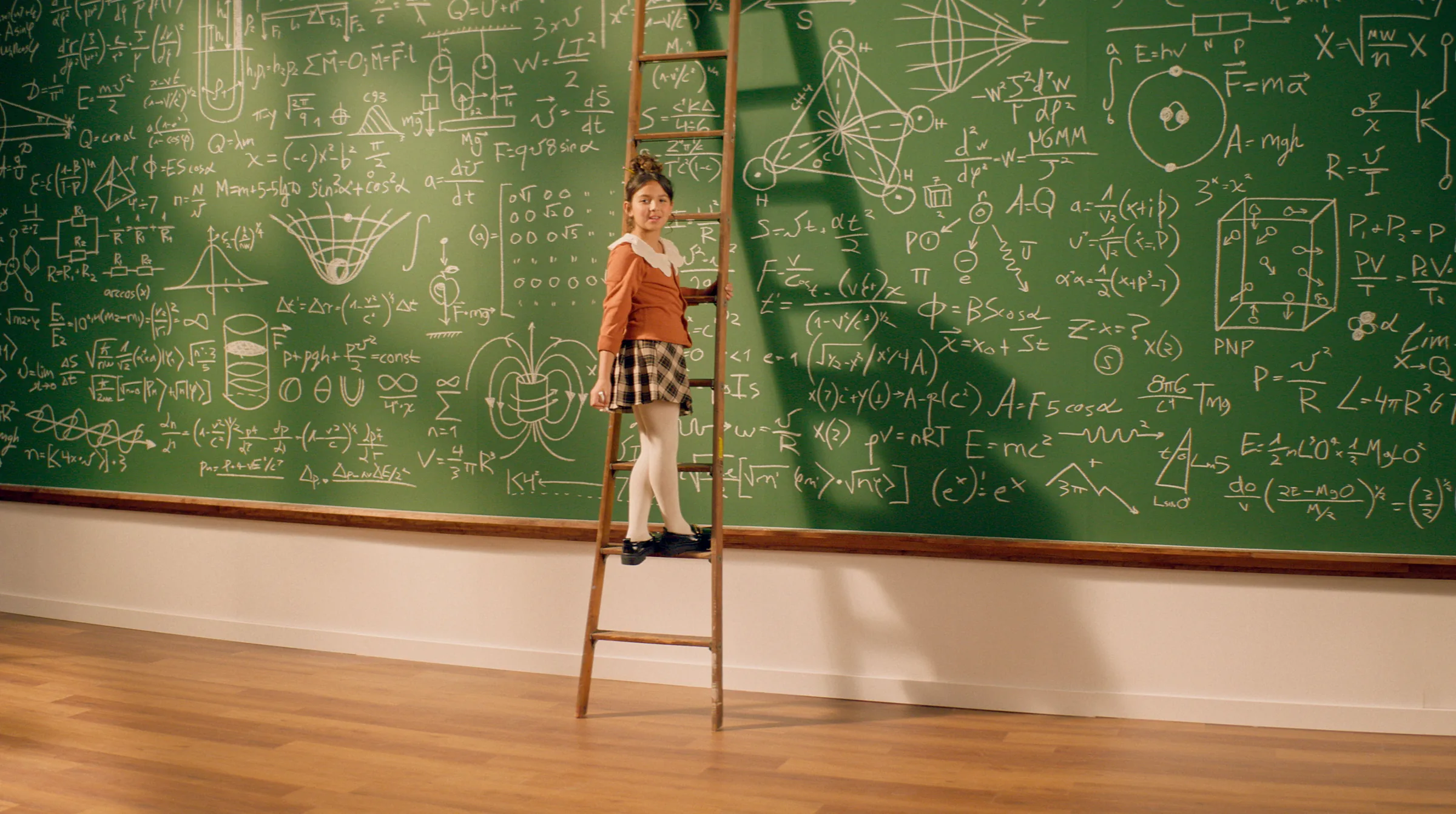 Child standing on a ladder before a wall of chalkboard equations